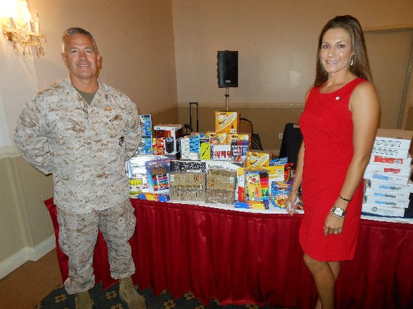 Col. James Turner, USMC, chapter president, and Mary Allison Yourchisin, chapter second vice president, stand next to school supply items collected by the Young AFCEANs at the September luncheon.